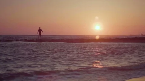 Happy man standing on the beach with hands raised at sunset. Beautiful sand seas Stock Footage 80438951