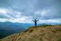 The happy man standing on the mountain on the rainy clouds background Photo