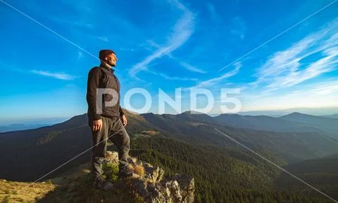 The happy man standing on the rock Stock Photos
