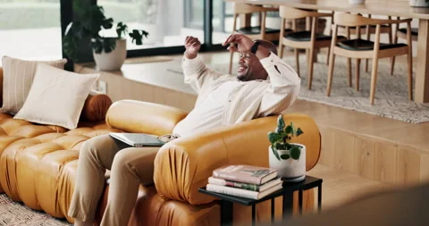 Happy man, stretching and creative with laptop in lounge, relax and freelancer Stock Footage 336853513