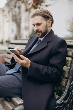 Happy man in suit using mobile outdoors Stock Photos