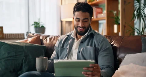 Happy man, tablet and watching with coffee on sofa for online entertainment or Stock Footage 314032881