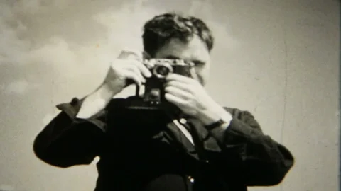 Happy man takes photos with a 35 mm camera 1950s family home movie 6458 Stock Footage 149850295