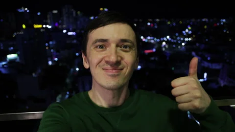 Happy man taking selfie giving thumbs up at night Stock Footage 344283340