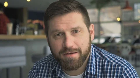 Happy man talking to camera, portrait, in cafe, very close steadicam shot 库存影片 72952388