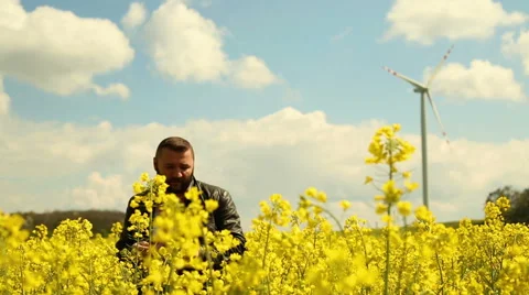 Happy man talking at the cell phone on the field of rapeseed Video stock 62861473
