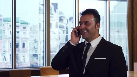 A happy man is talking on his mobile phone in the office Stock Footage 84126439
