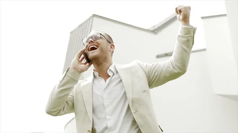 Happy man talking on the phone making victory fist after getting good news Видео 42946591