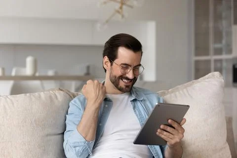 Happy man use tablet win online lottery Foto stock