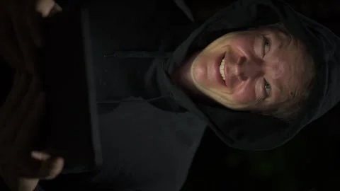Happy man using digital tablet computer outdoors at night while smiling Stock Footage 317368936