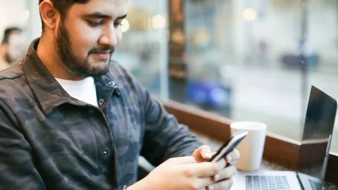 Happy man using mobile phone in cafe. Sending selfie to friends. Video footage Stock Footage 85311434