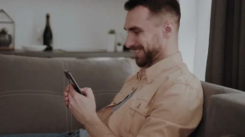 Happy man using mobile phone at home Stock Footage 155357612