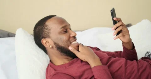 Happy man using mobile phone in bed Video stock 156519760