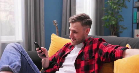 Happy man using smart phone at home. Smiling young student boy at home sitting Stock-Footage 153900794
