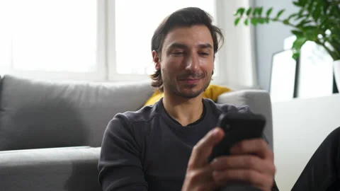 Happy man using smartphone at home Stock Footage 149256343