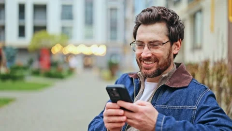 Happy Man Using Smartphone in Urban Setting Stock-Footage 320928106