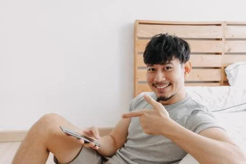 Happy man using smartphone while relax in his apartment. Stay at home. Stock-Fotos
