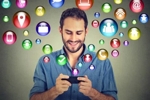 Happy man using texting on smartphone social media application icons flying o Stock Photos