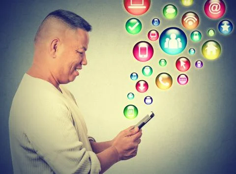 Happy man using texting on smartphone social media application icons flying u Stock Photos