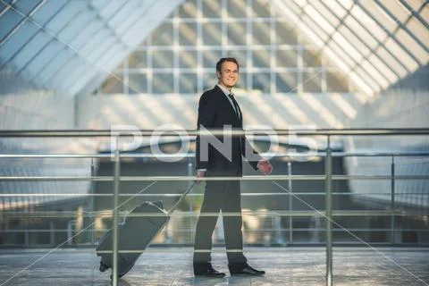 The happy man walk with a suitcase in the business center Stock Photos