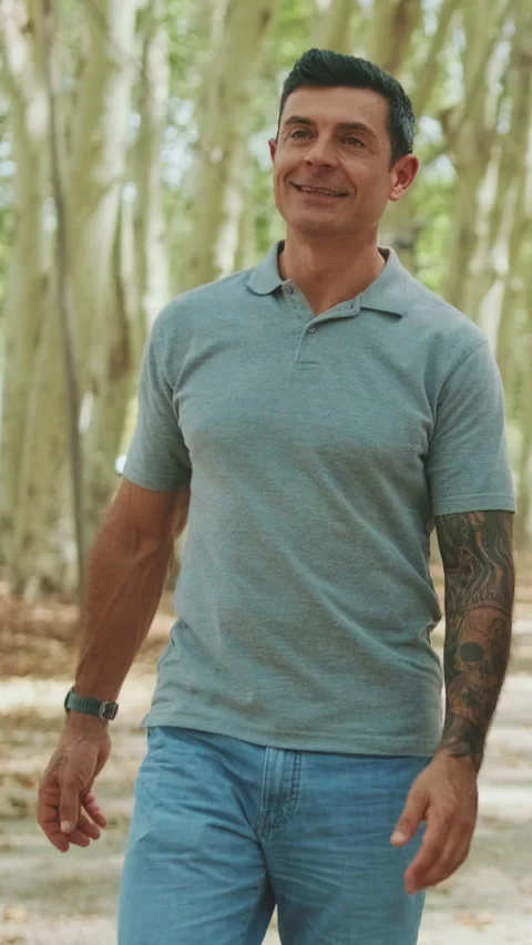 Happy man walking through the park and talking to someone Stock Footage 255962290