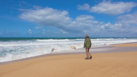 Happy Man Walks on an Ocean Beach Stock Footage 90093591