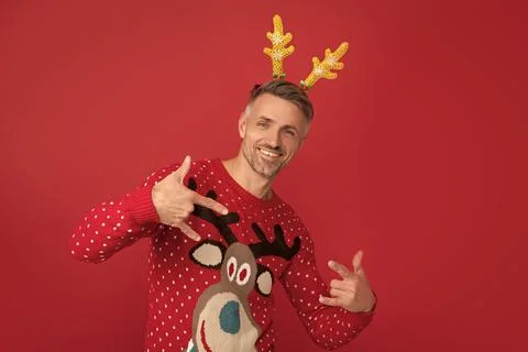 Happy man in winter sweater and party antlers. xmas guy on red background. happy Stock Photos