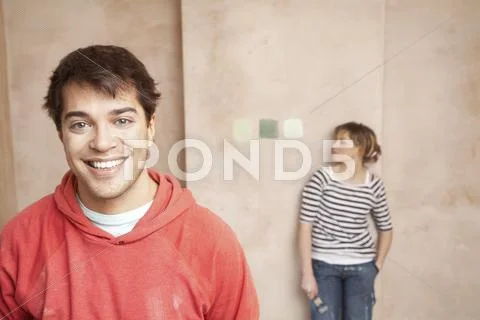 Happy Man With Woman Looking At Color Samples On Wall Stock Photos