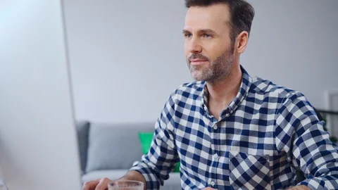 Happy man working on computer from home office then looking at camera Stock Footage 126830493