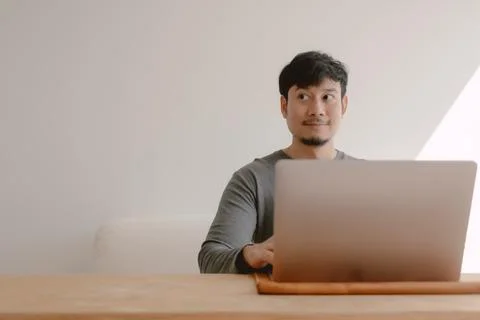 Happy man working with computer over empty space white wall. Foto stock