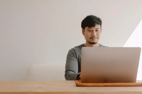 Happy man working with computer over empty space white wall. Foto stock