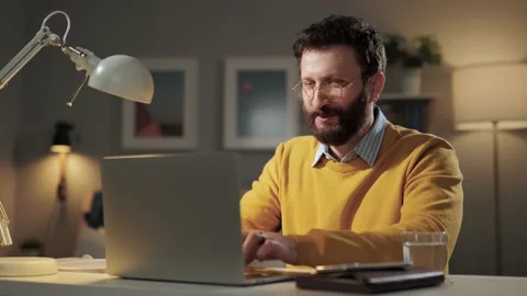 Happy man working at computer. Smiling laughing bearded man with glasses at home Video stock 170472885