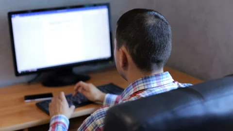 Happy man working in an office at a computer Video stock 92407147