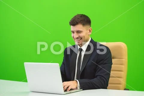 The happy man works with the laptop on the green background Stock Photos