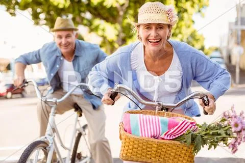 Happy mature couple going for a bike ride in the city Stock Photos