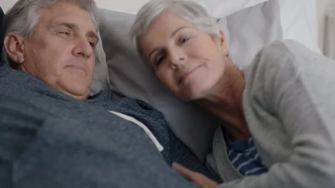 happy mature couple lying in bed cuddlin... | Stock Video | Pond5