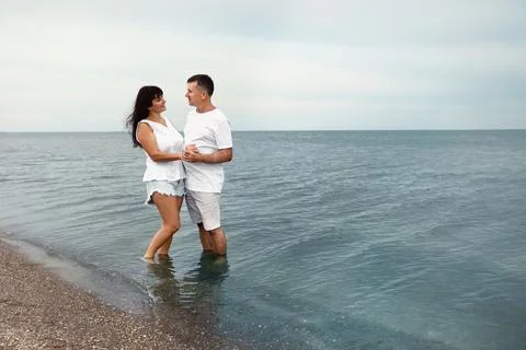 Happy mature couple spending time together on sea beach. Space for text Stock Photos