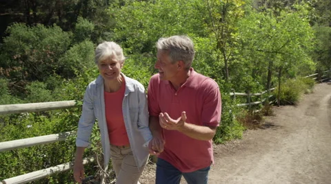 Happy mature couple walking on trail Stock Footage