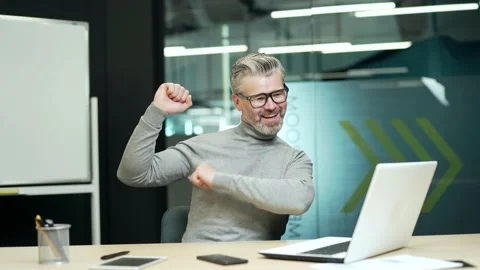 Happy mature gray haired bearded businessman in glasses is happy and dancing at  Stock Footage 232575139