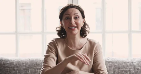 Happy mature lady talking to camera video calling at home Stock Footage 125540334
