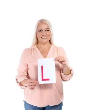Happy mature woman with L-plate on white background. Getting driving license Stock Photos