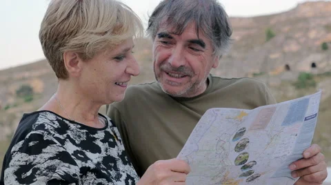 Happy middel- age couple talking quietly looking at the map Vídeos de archivo 67810347