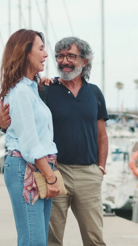 Happy middle aged couple planning sea voyage while standing in the port Stock Footage 252207655