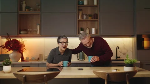 Happy middle-aged man and his wife joking and laughing, drinking tea together Stock Footage 340920115