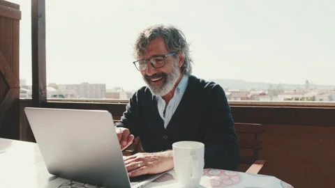 Happy middle aged man communicates remotely using laptop. Working from home Vídeo Stock 229507665