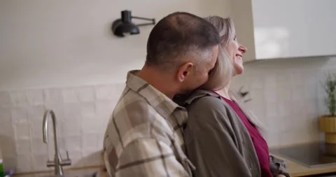 Happy middle aged man holding his wife back and hugging her while dancing in the Stock Footage 313277136