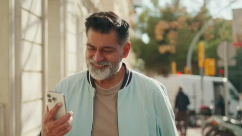 Happy Middle-aged Man Smiling While Using Smartphone Outdoors Stock Footage 329933562