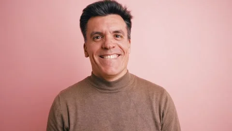 Happy middle aged man smiling and laughing on a pink background Stock Footage 339039497