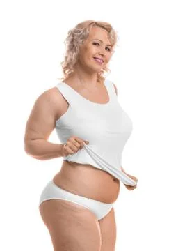 Happy middle aged plus size model in white lingerie over white background. Stock-Fotos