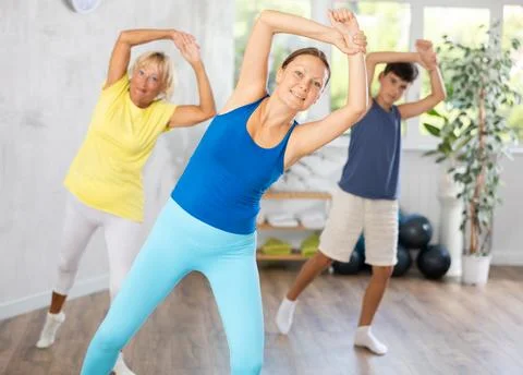 Happy middle-aged woman practicing dance positions during workout session Stock Photos